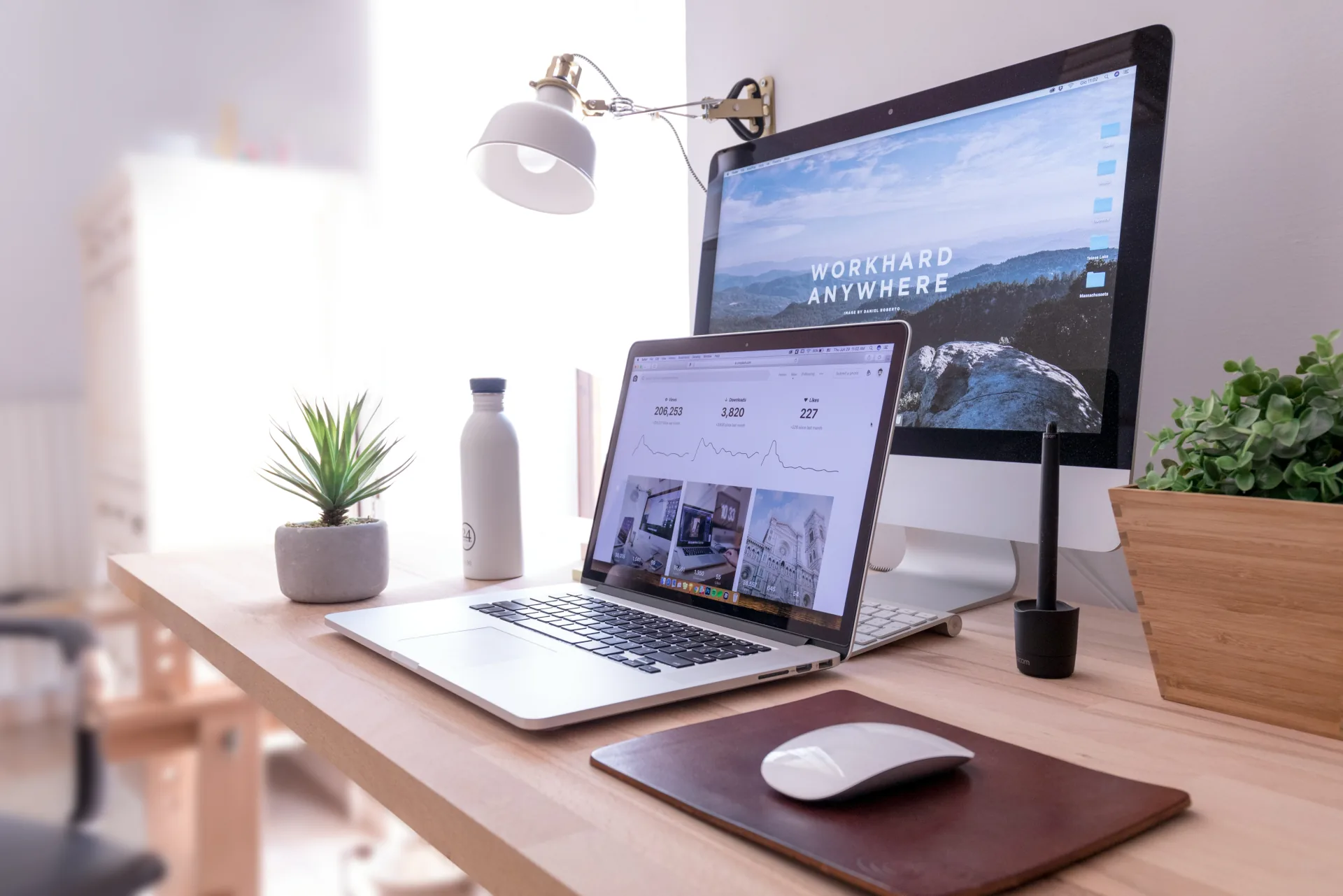 Escritorio con un sitio web abierto en un monitor y un panel de métricas en una laptop